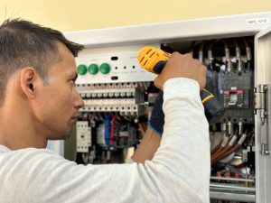 Engineer-inspecting-power-distribution-unit-for-reliable-rack-power-management-scaled