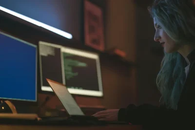 Cybersecurity specialist managing backup and disaster recovery systems on multiple monitors.