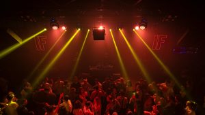 Crowd dancing under bright lights, showing how clean air boosts comfort and energy.