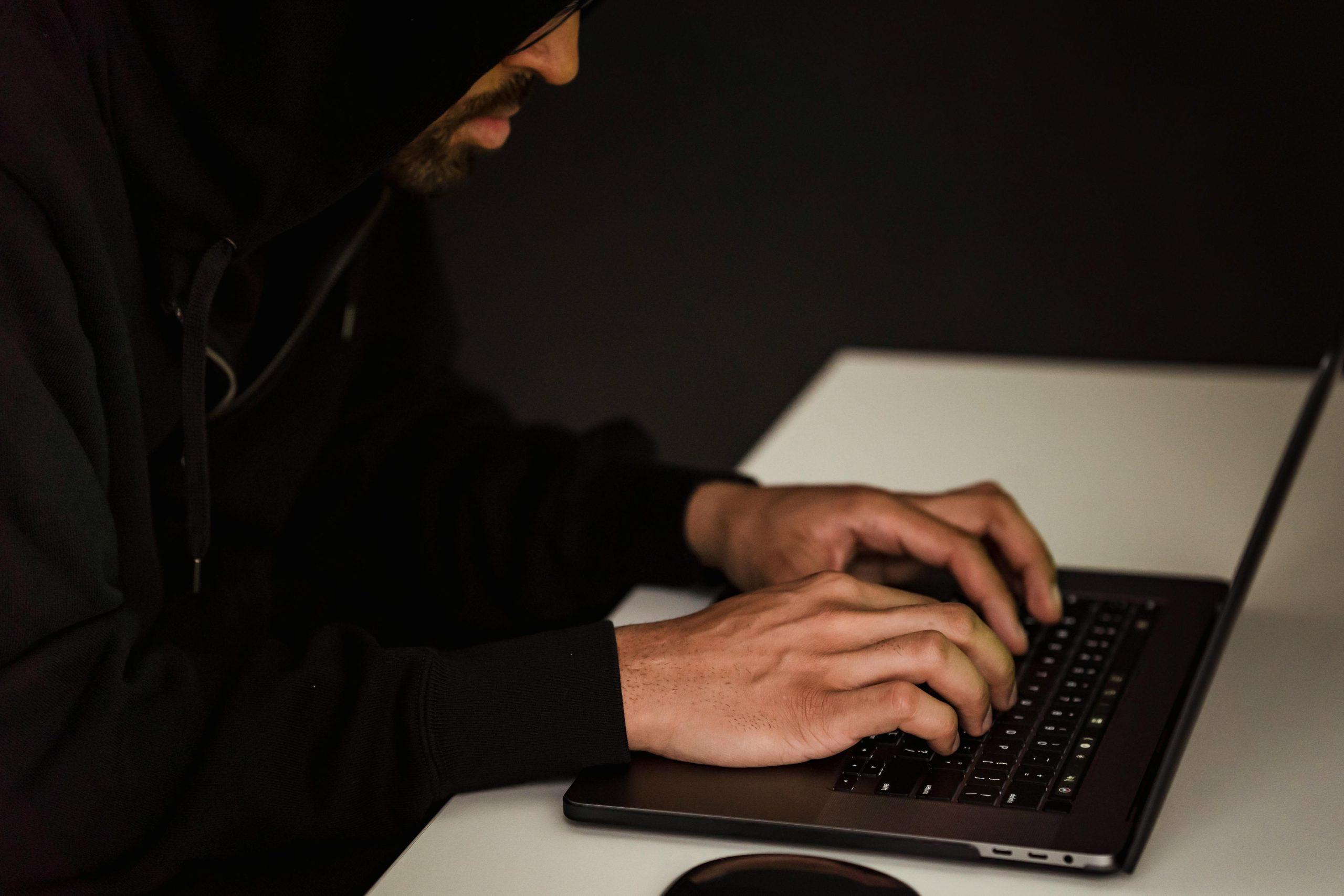 Hacker using a laptop representing cyber threats and security risks